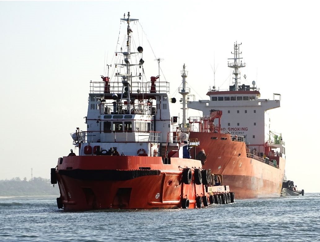 red anchor handling tug towing vessel